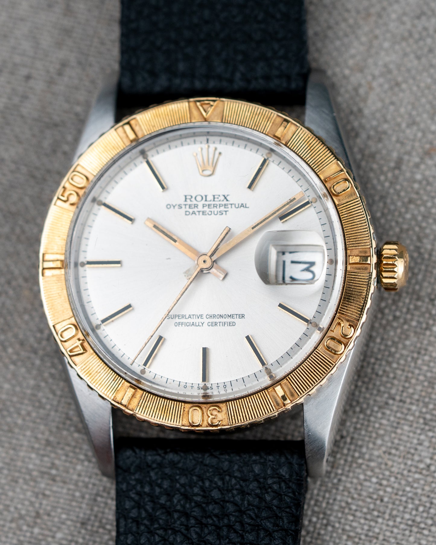 Rolex watch with gold and silver case on a gray background