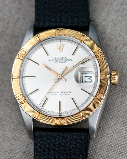 Rolex watch with gold and silver case on a gray background